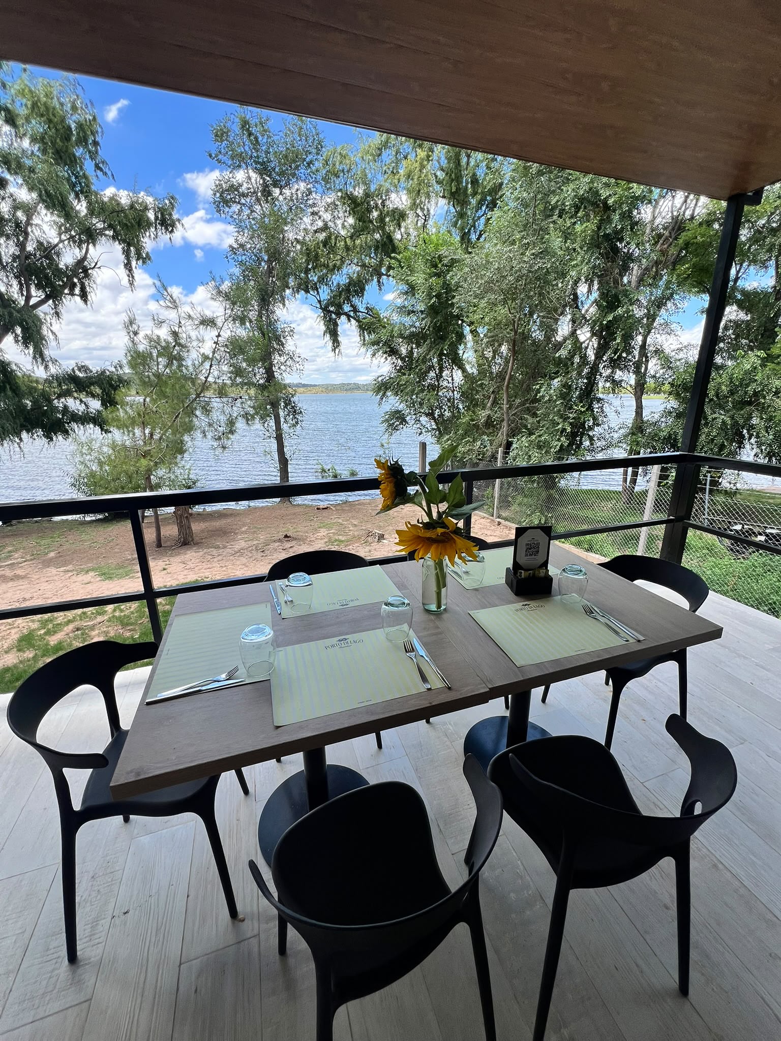 Table set for two on the deck, overlooking the lake through the trees