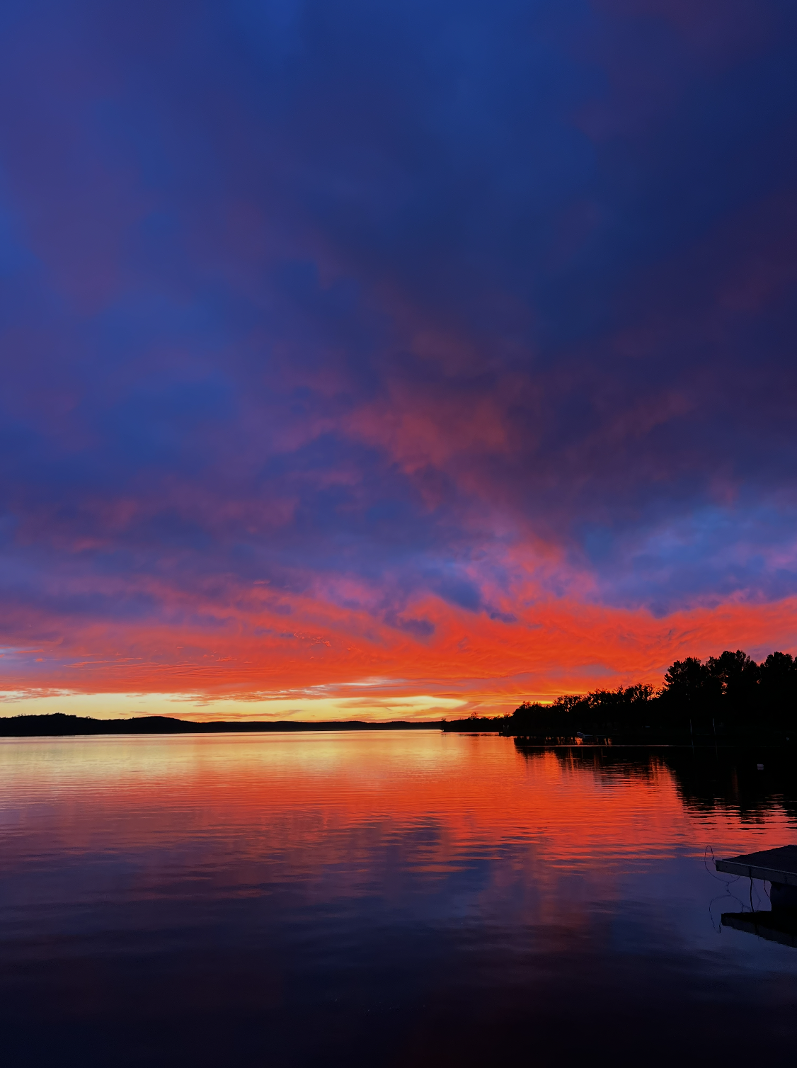 Fiery sunset over Embalse La Florida, reflected in the still lake